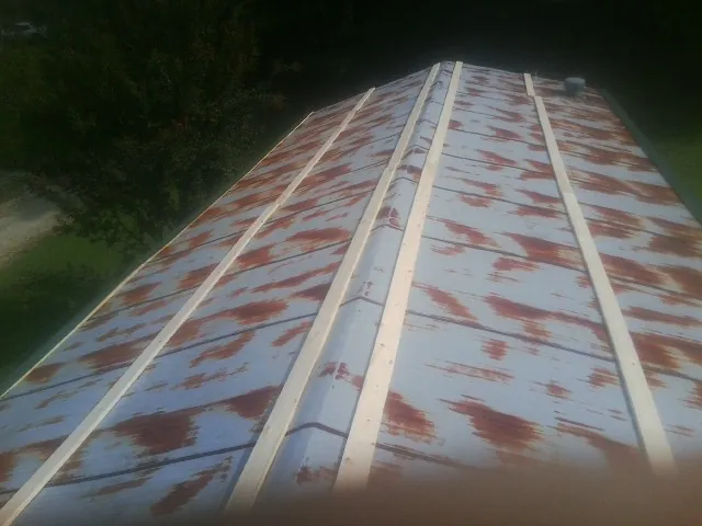 Rusted metal roof panels with new wood purlins before replacement — Storm Damage Roof Repair in Lillian by Roofing Brothers