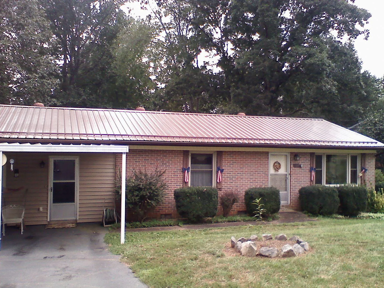 Bronze metal roof and carport on a brick ranch home — Roof Repair work by our crew in Lillian