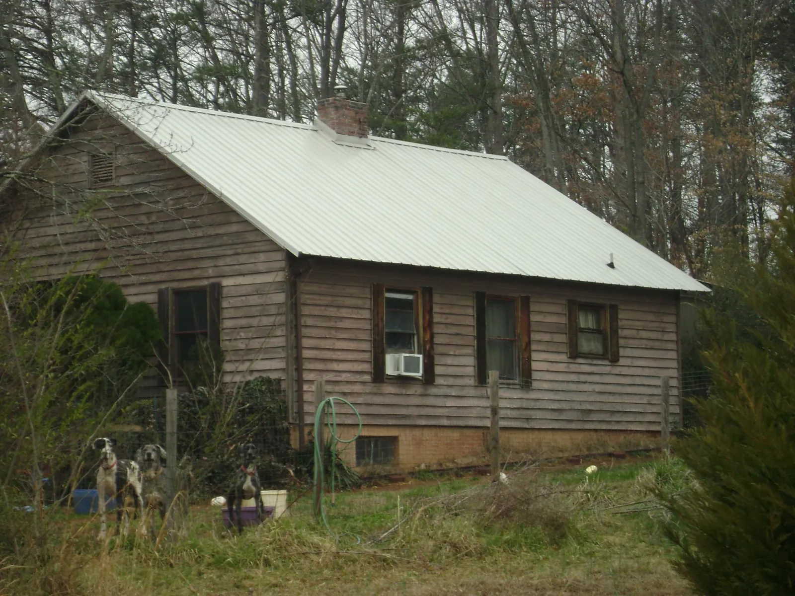 White metal roof on an old wood sided farmhouse, from a Metal Roof Installation job in Lillian
